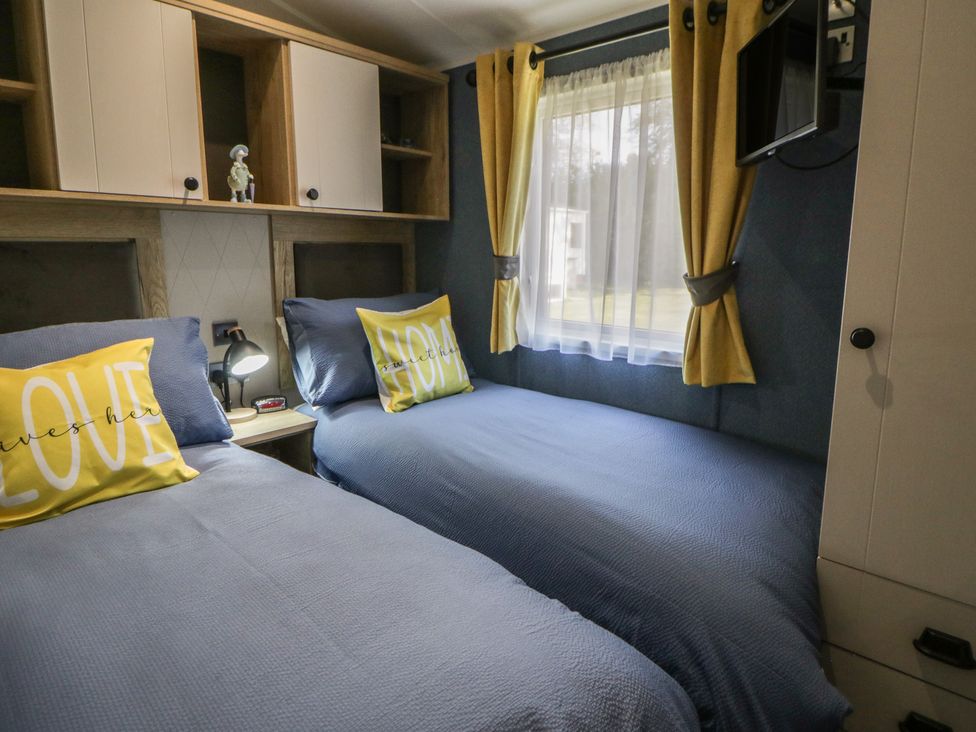 A bedroom with two beds and a window at Santa Maria in Llandysul