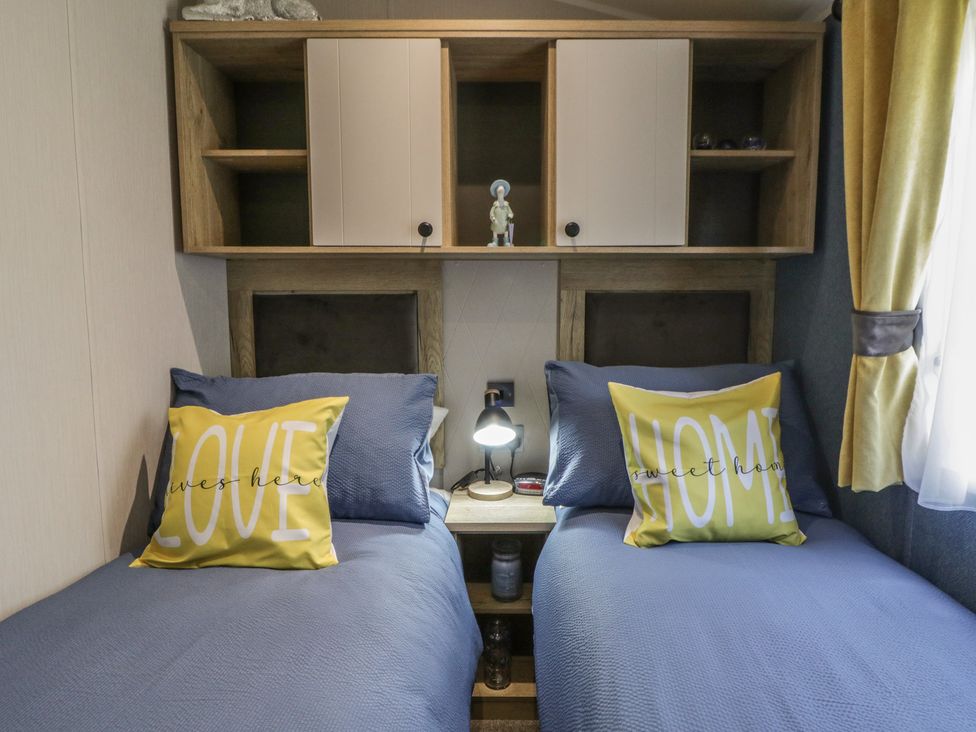 A bedroom with two beds and decorative items at Santa Maria in Llandysul