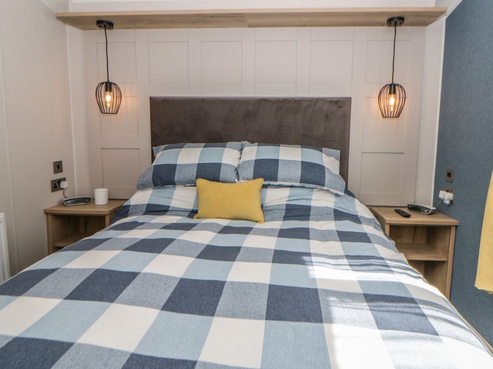 A bedroom with a bed and lamps at Santa Maria in Llandysul