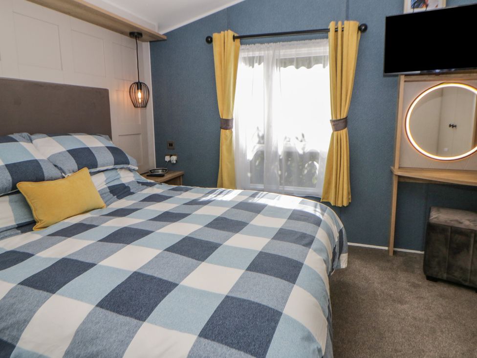 A bedroom with a bed and television at Santa Maria in Llandysul
