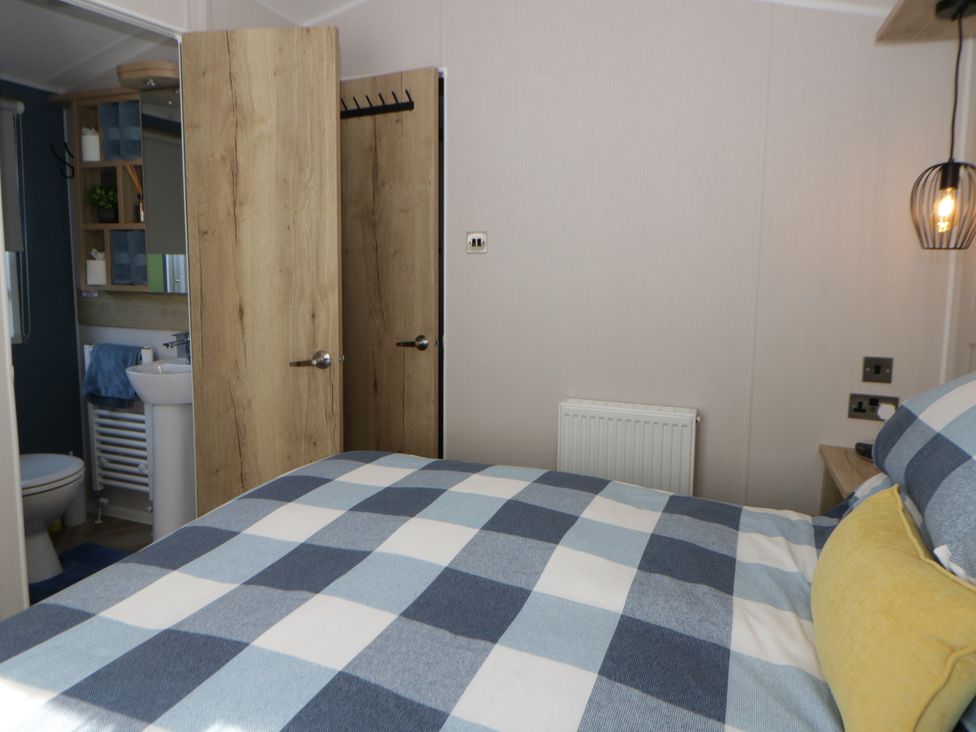 A bedroom with a view of the bathroom door at Santa Maria in Llandysul