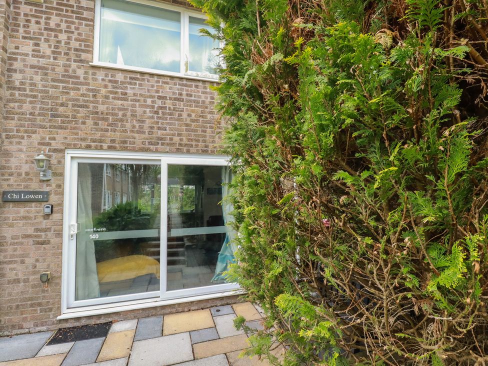 An exterior view of a house with a sliding door and hedge at Chi Lowen in Newquay