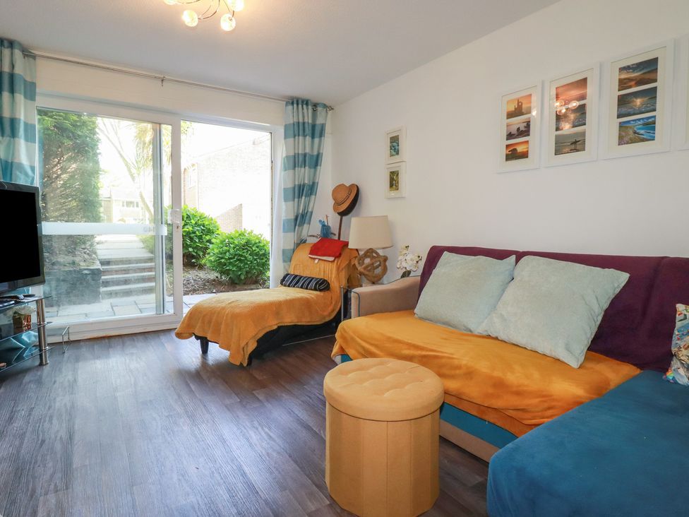 A living room with a sofa and television at 140 Atlantic Reach in Newquay