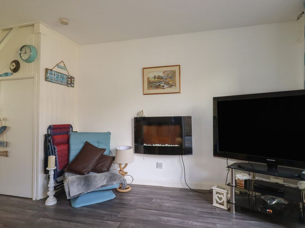 A living room with a television and fireplace at 140 Atlantic Reach in Newquay