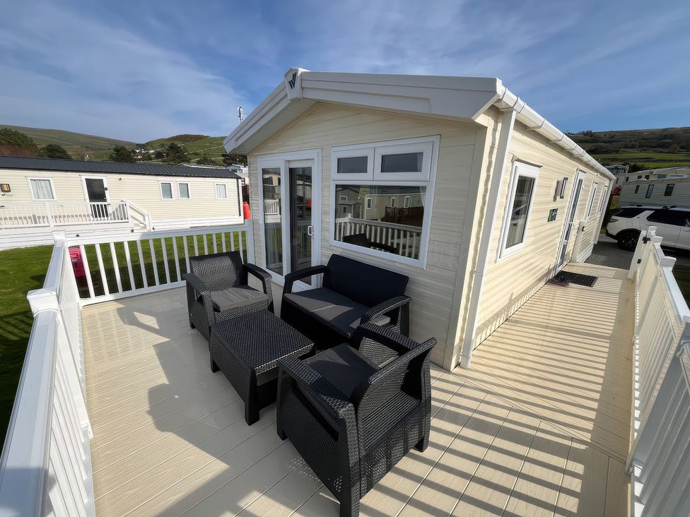 An outdoor seating area with chairs and a table at 26 Ocean View in Llwyngwril
