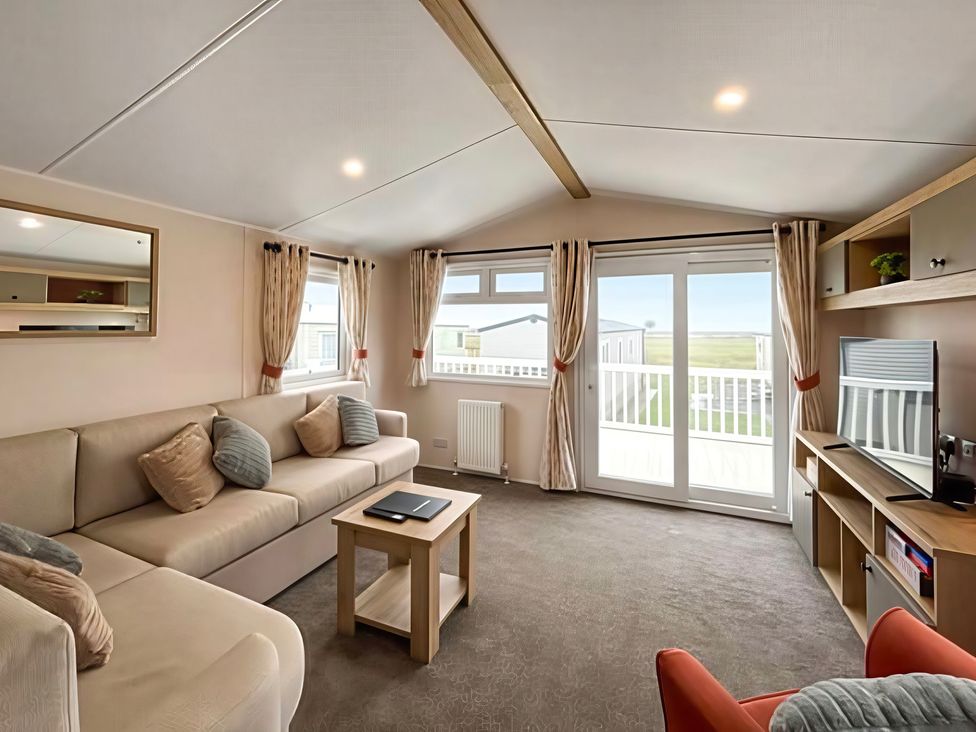 A living room with a sofa and coffee table at 26 Ocean View in Llwyngwril