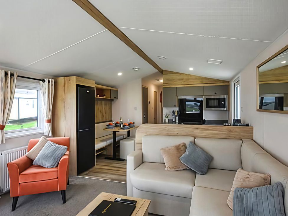 A living room with a sofa and dining table at 26 Ocean View in Llwyngwril