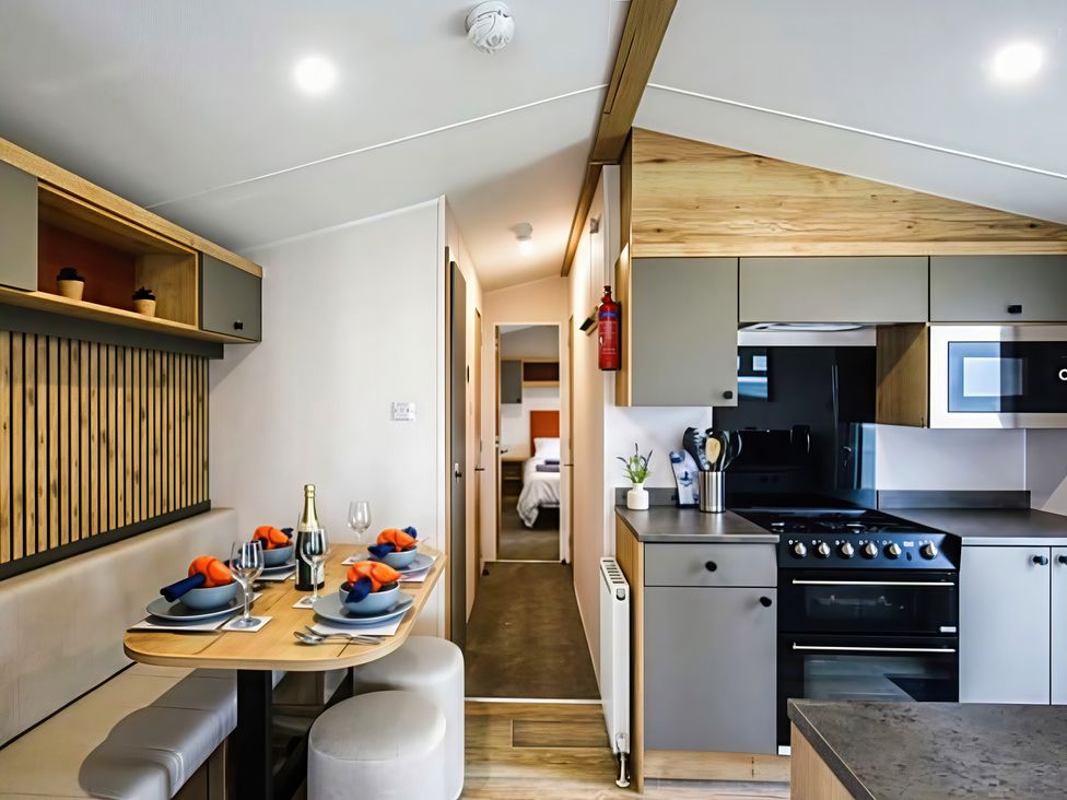 A kitchen with dining area and appliances at 26 Ocean View in Llwyngwril