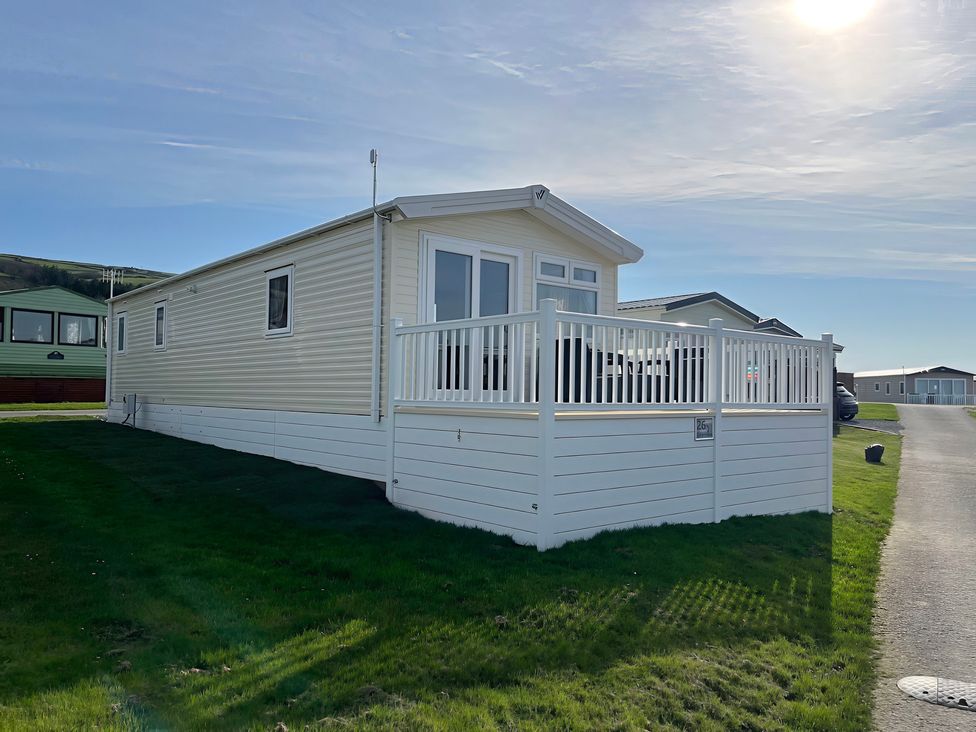 A mobile home with a veranda and grass at 26 Ocean View in Llwyngwril