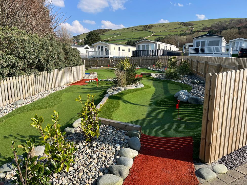 A garden with artificial grass and defined pathways at 26 Ocean View, Llwyngwril