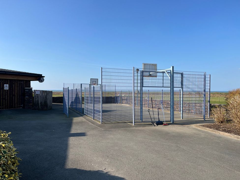 An outdoor basketball court next to a building at 26 Ocean View in Llwyngwril