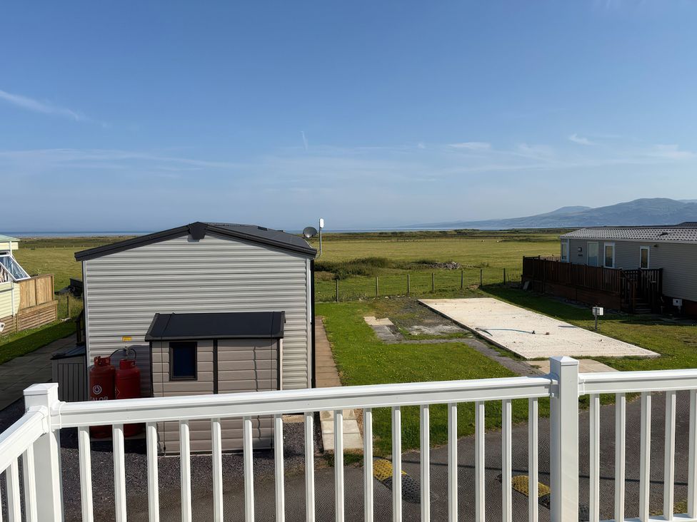An outdoor area with a view of caravans and ocean at 26 Ocean View, Llwyngwril