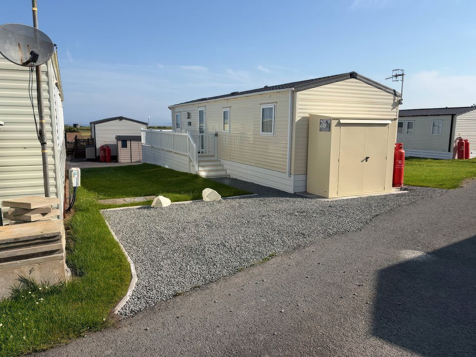 A trailer with a storage shed and gravel driveway at 26 Ocean View in Llwyngwril