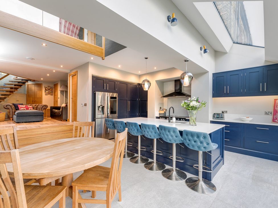 A kitchen with a dining area and bar stools at The Grand Weave House in Shipley