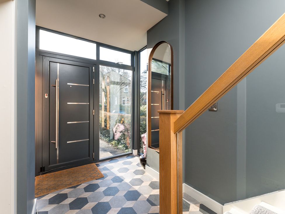 A hallway with a front door and staircase at The Grand Weave House in Shipley