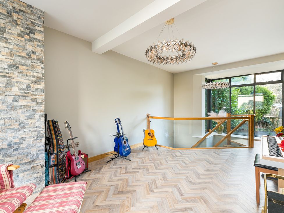 A living room with guitars and a piano at The Grand Weave House in Shipley