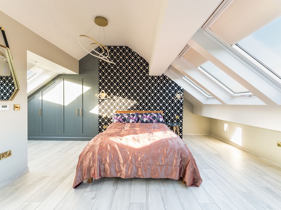 A bedroom with a bed and wardrobe at The Grand Weave House in Shipley