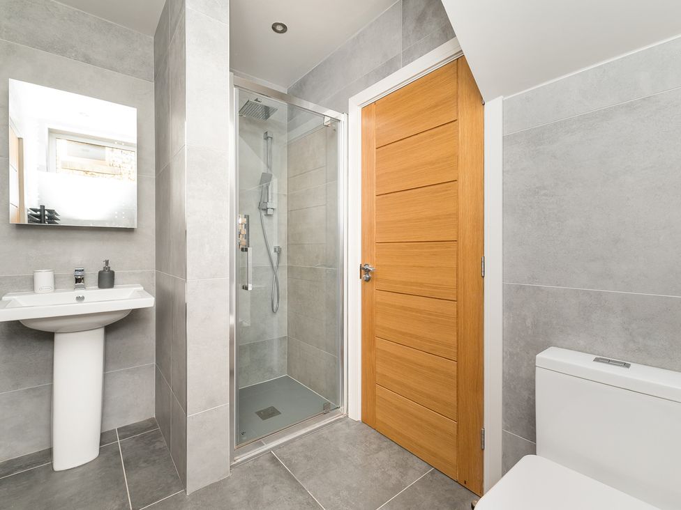 A bathroom with a shower, sink, and toilet at The Grand Weave House in Shipley