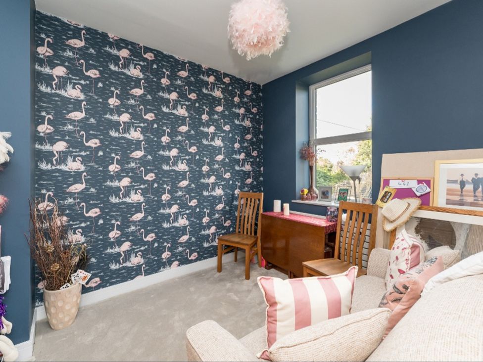 A sitting room with flamingo wallpaper and a table at The Grand Weave House Shipley