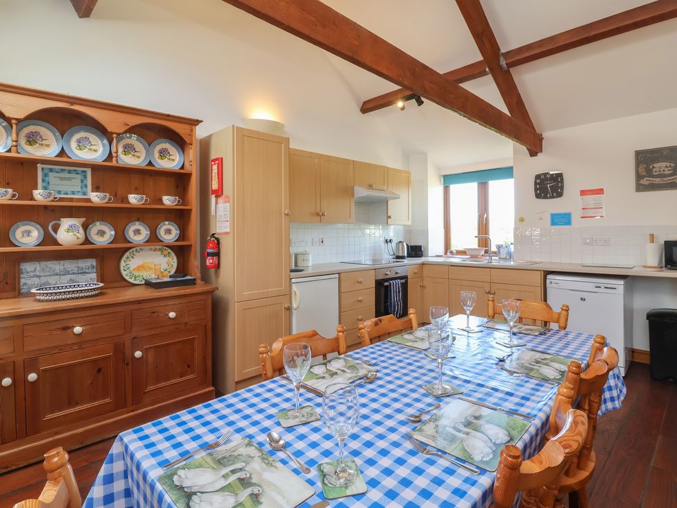 A kitchen with a wooden table and chairs at Little Owl Barn Wellington