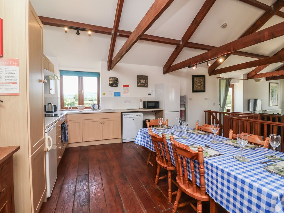 A kitchen with a dining table and chairs at Little Owl Barn in Wellington
