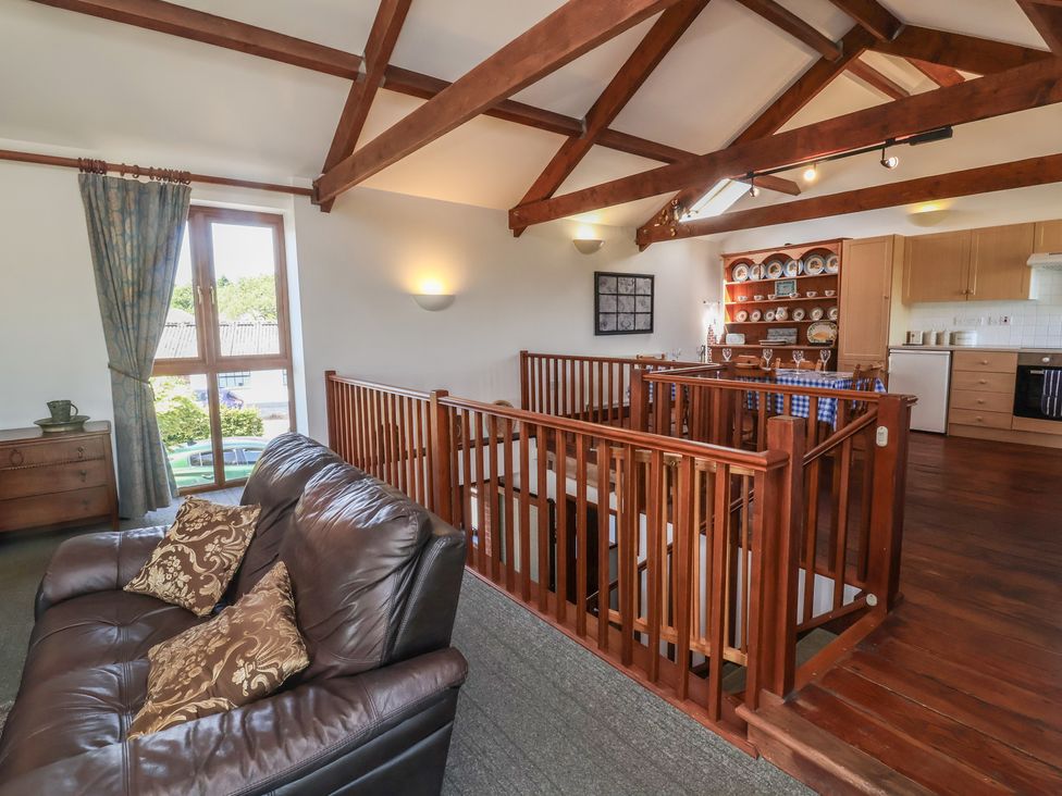A living room with a sofa and a staircase at Little Owl Barn in Wellington