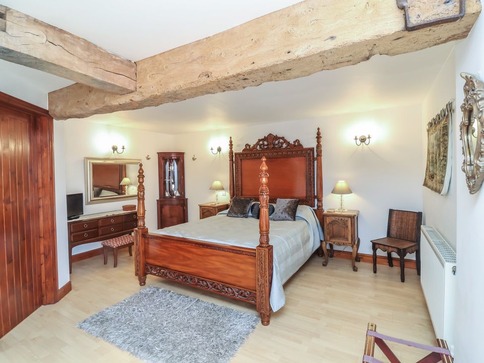 A bedroom with a wooden bed and furniture at Little Owl Barn in Wellington