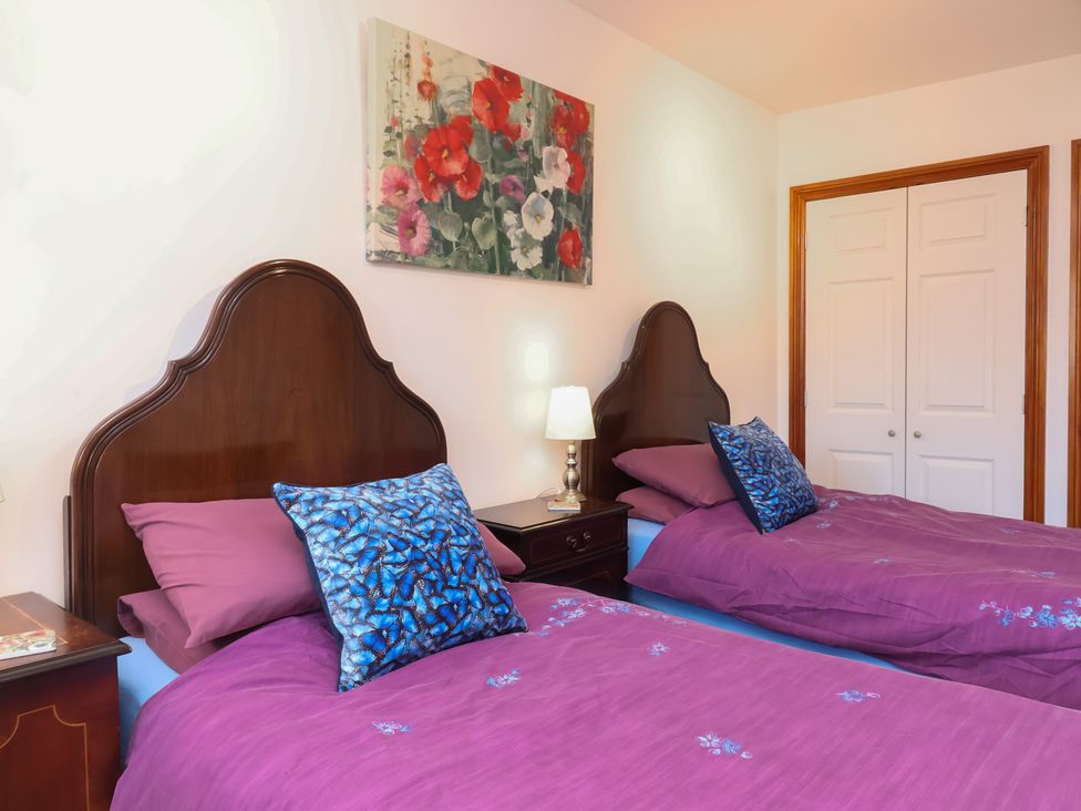 A bedroom with two beds and a painting at Little Owl Barn in Wellington