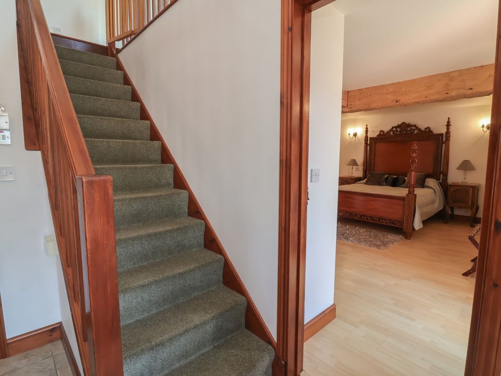 A hallway with stairs leading to a bedroom at Little Owl Barn in Wellington