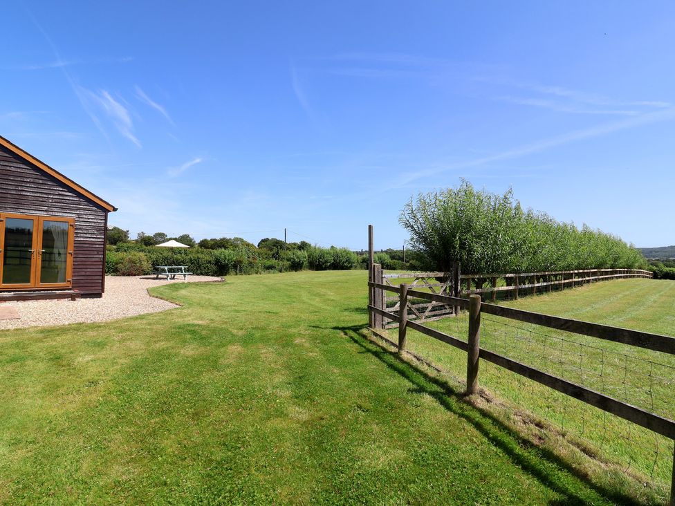 An outdoor area with a wooden building and grassy lawn at Little Owl Barn in Wellington