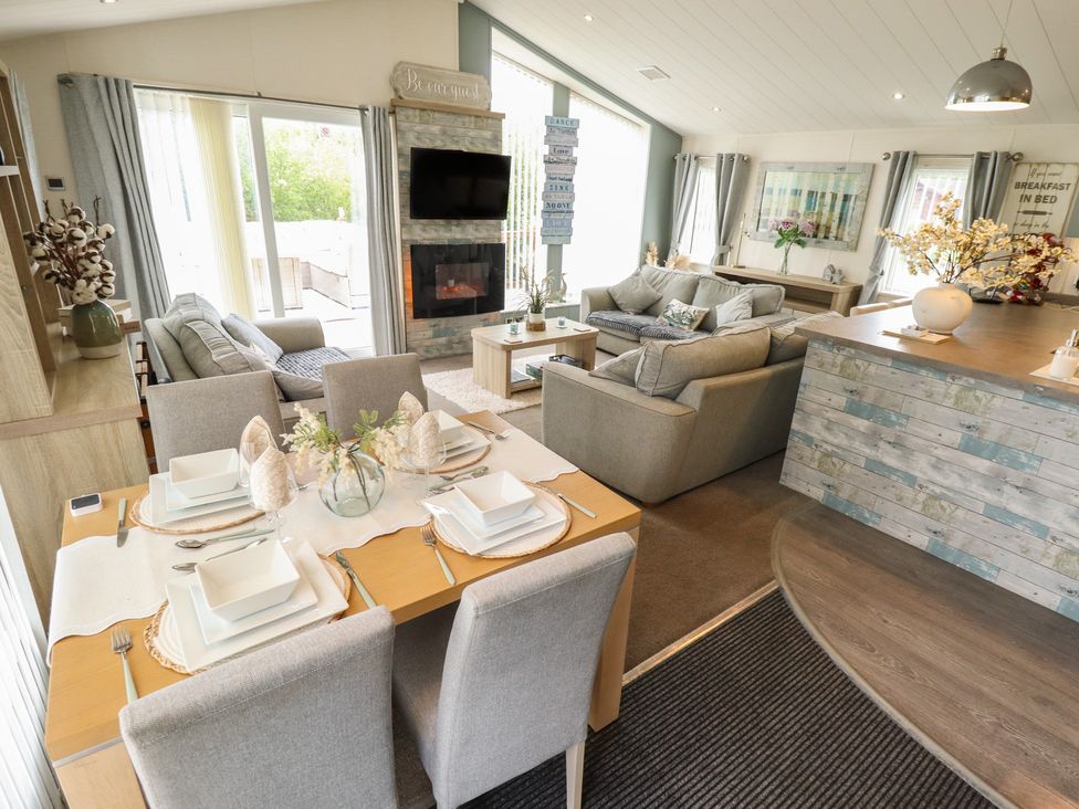 A living room with a sofa, dining area, and television at P and M Luxury Lodge BR15 Tattershall