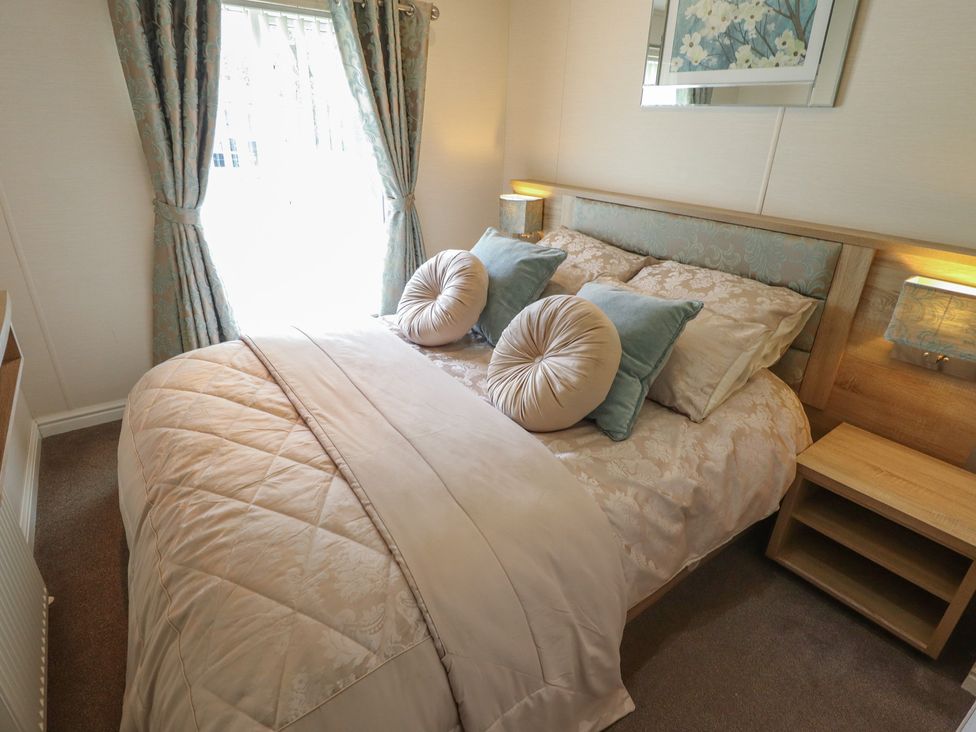 A bedroom with a bed, pillows, and curtains at P and M Luxury Lodge BR15 in Tattershall
