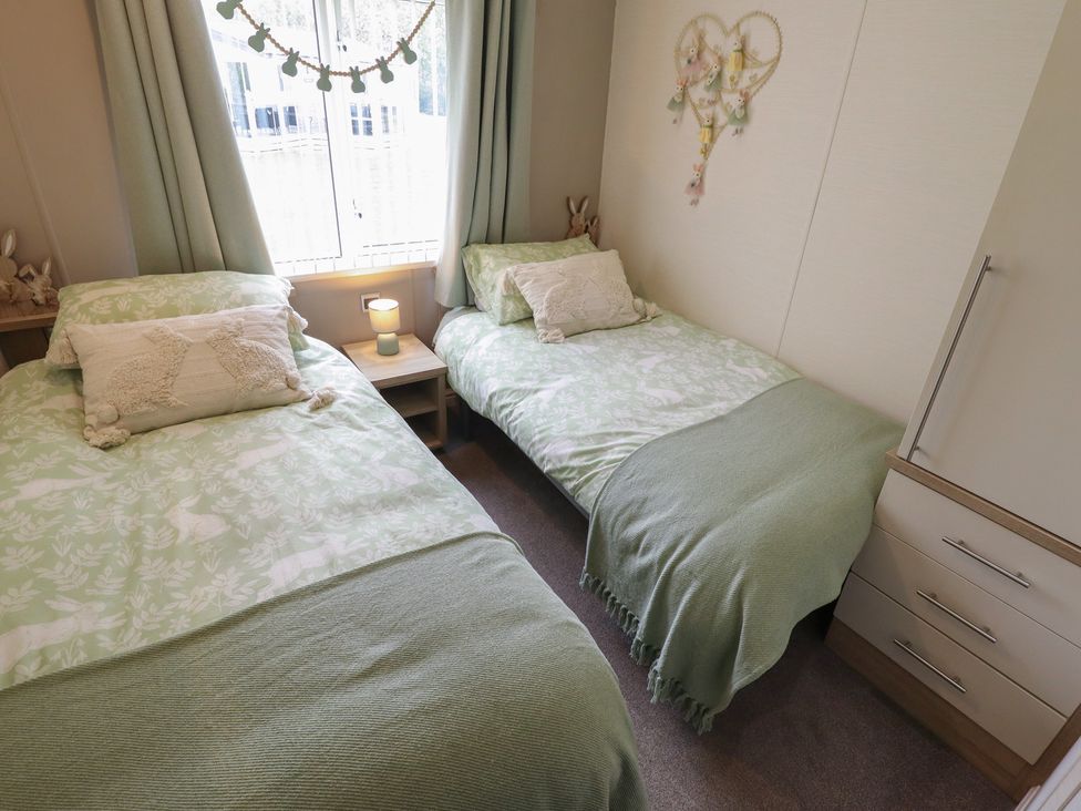 Two beds with green covers in a bedroom at P and M Luxury Lodge BR15 Tattershall