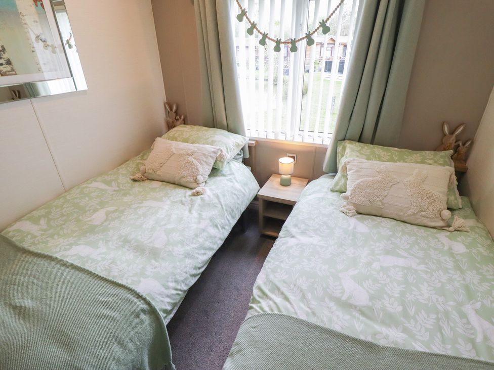 A bedroom with two beds and a bedside table at P and M Luxury Lodge BR15 in Tattershall
