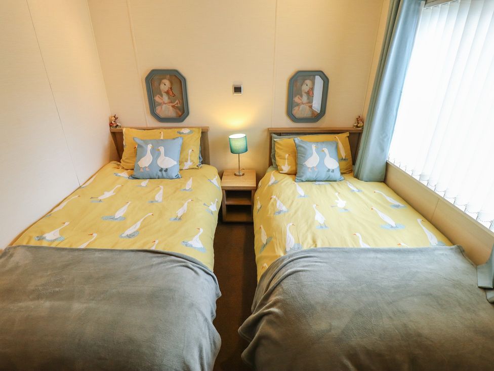 A bedroom with two beds and a lamp at P and M Luxury Lodge BR15 in Tattershall