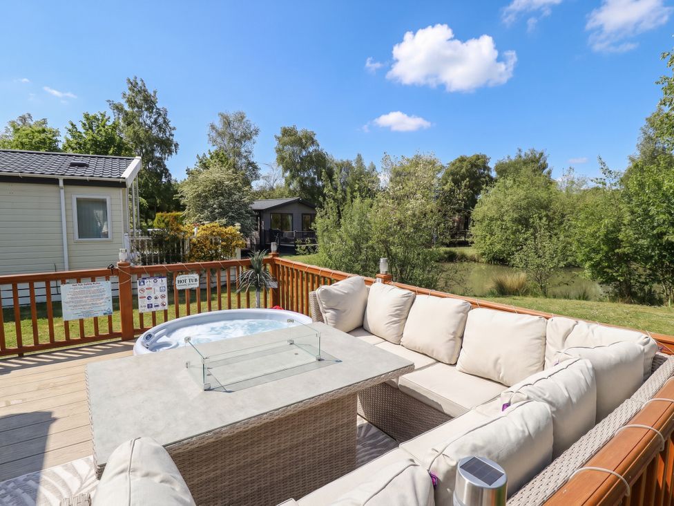 An outdoor seating area with a hot tub and coffee table at P and M Luxury Lodge BR15 Tattershall