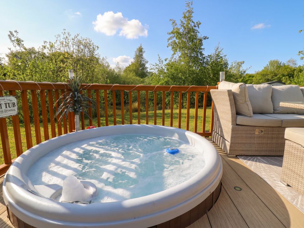 An outdoor area with a hot tub and sofa at P and M Luxury Lodge BR15 Tattershall