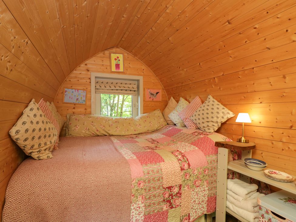 A bedroom with a bed and pillows at Bluebell Glamping Pod in Woolton Hill