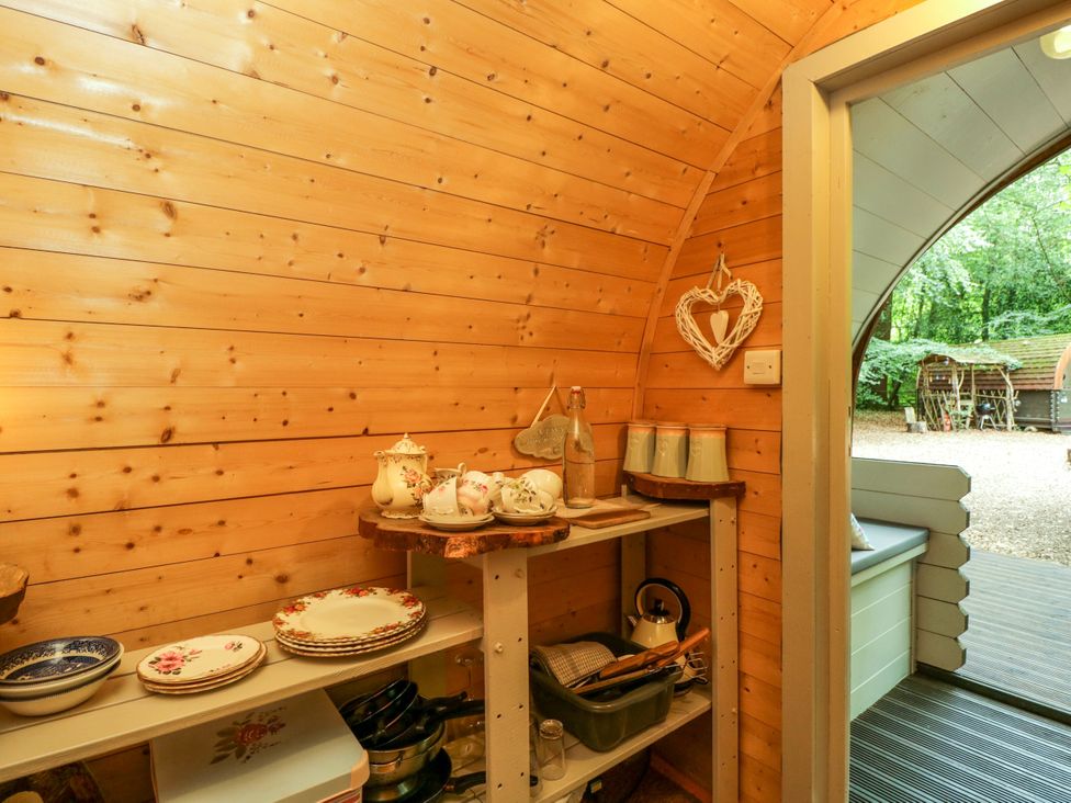 A kitchen area with shelves and plates at Bluebell Glamping Pod in Woolton Hill