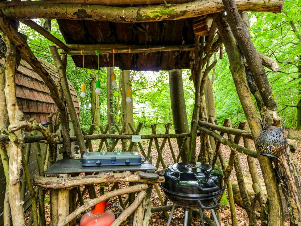 An outdoor cooking area with a grill and gas cylinder at Bluebell Glamping Pod in Woolton Hill