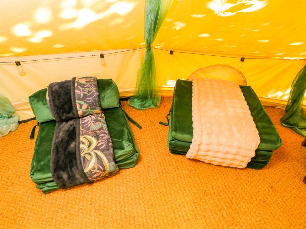 A sleeping area with mattresses and blankets at Jungle Bell Tent in Woolton Hill