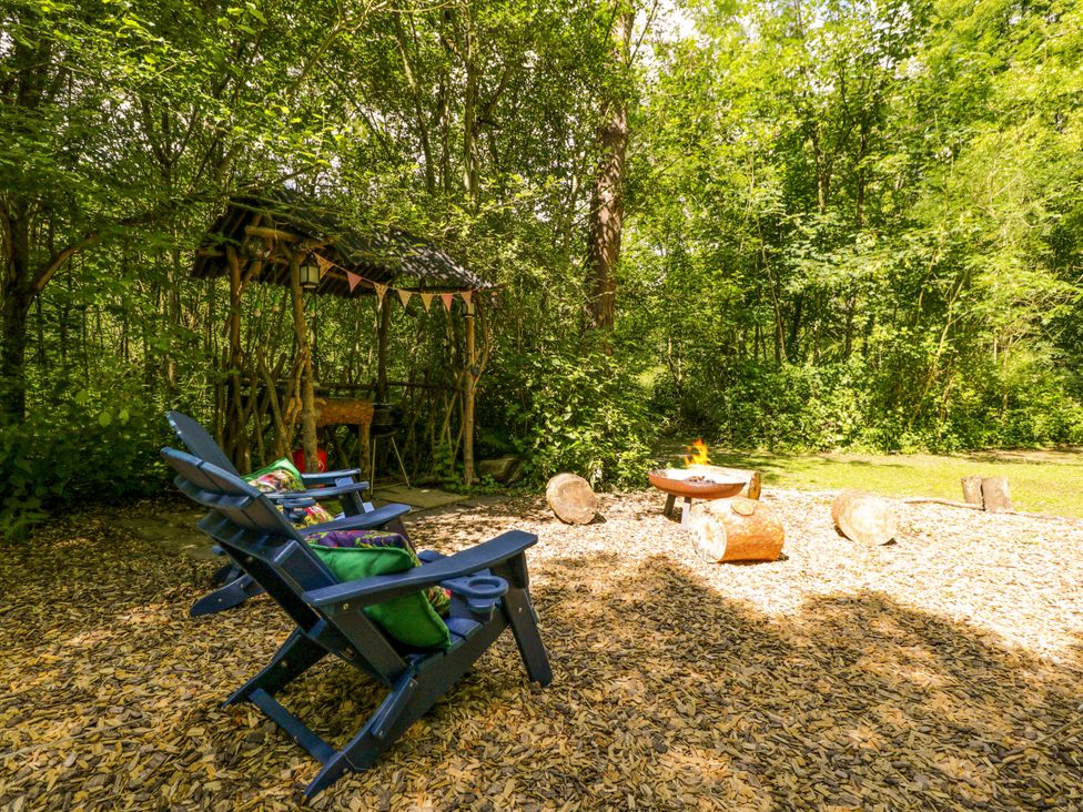 A seating area with chairs and a fire pit at Jungle Bell Tent Woolton Hill