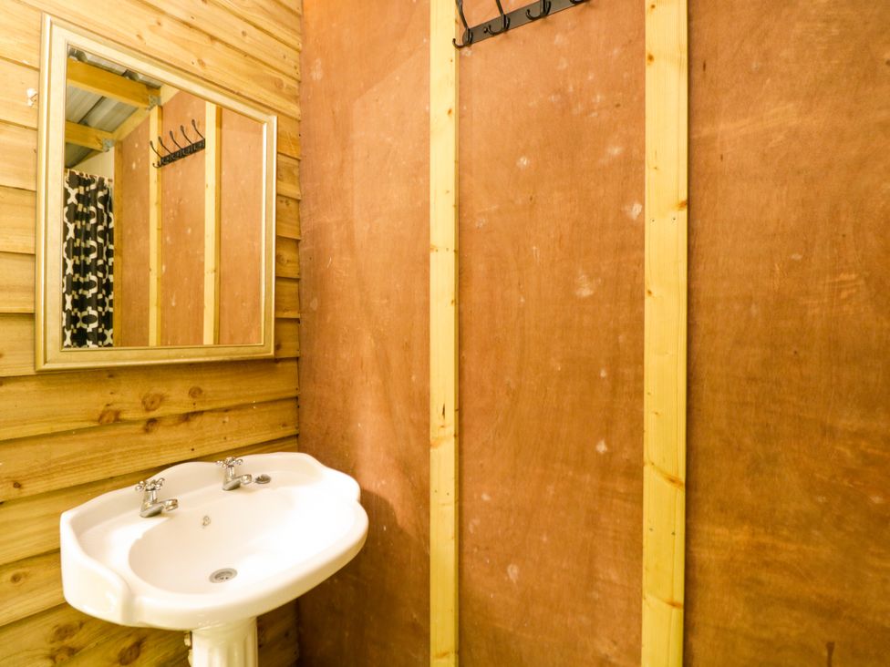 A bathroom with a sink and mirror at Jungle Bell Tent Woolton Hill