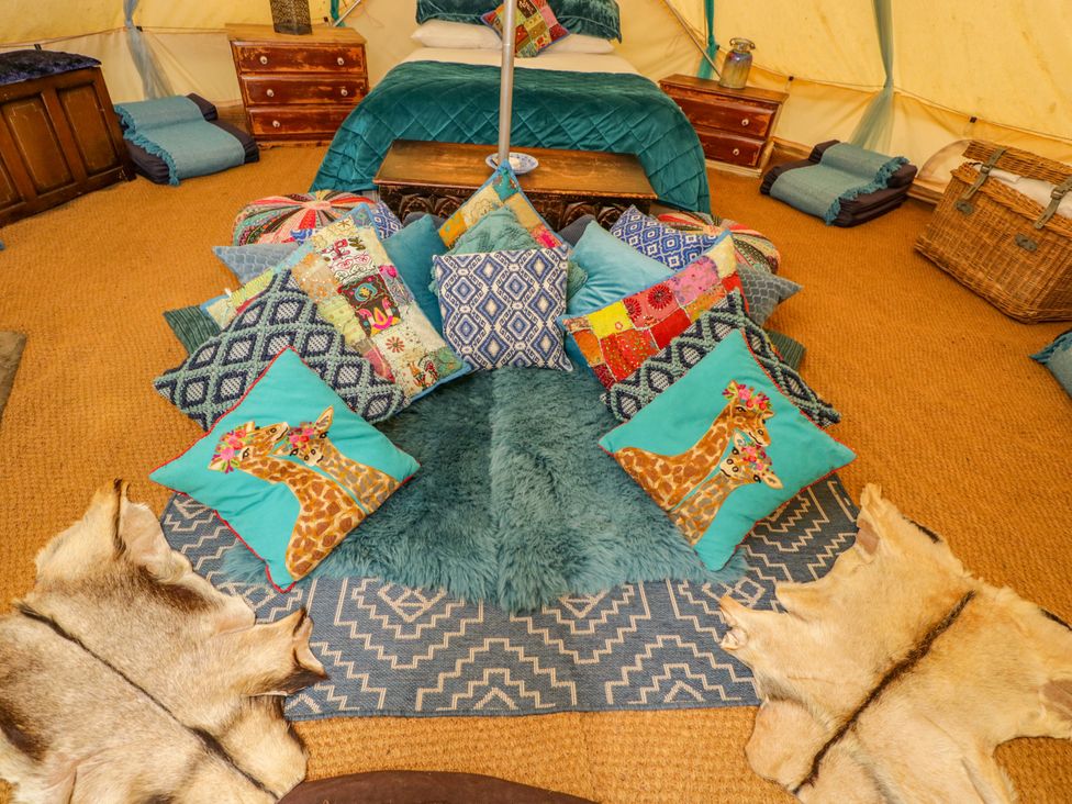 A cozy bedroom with pillows and a bed at The Moroccan Bell Tent in Woolton Hill