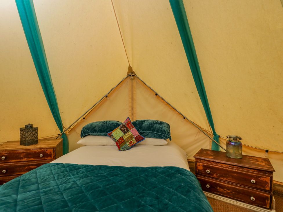 A bedroom with a bed and side tables at The Moroccan Bell Tent in Woolton Hill