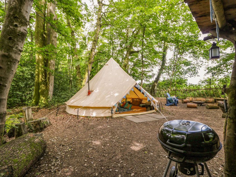 A tent with seating and a barbecue grill at The Moroccan Bell Tent in Woolton Hill