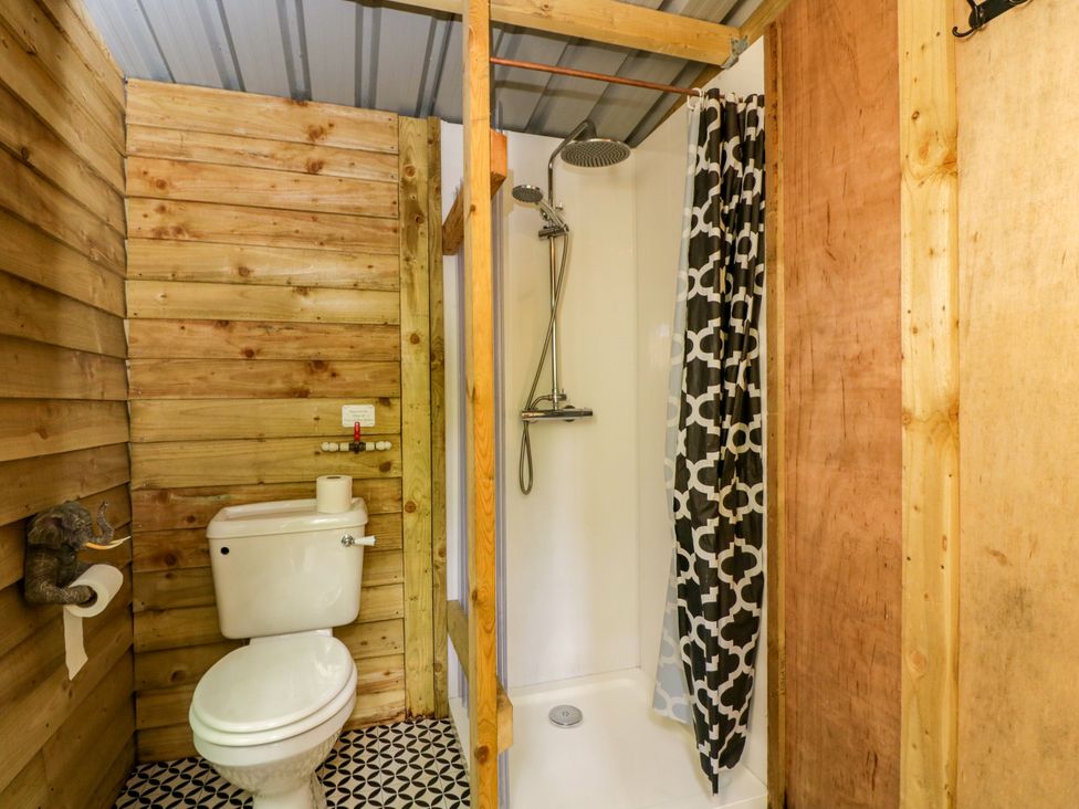 A bathroom with a shower and toilet at The Moroccan Bell Tent in Woolton Hill