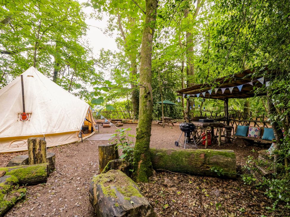 An outdoor area with a bell tent, seating, and barbecue grill at The Moroccan Bell Tent in Woolton Hill