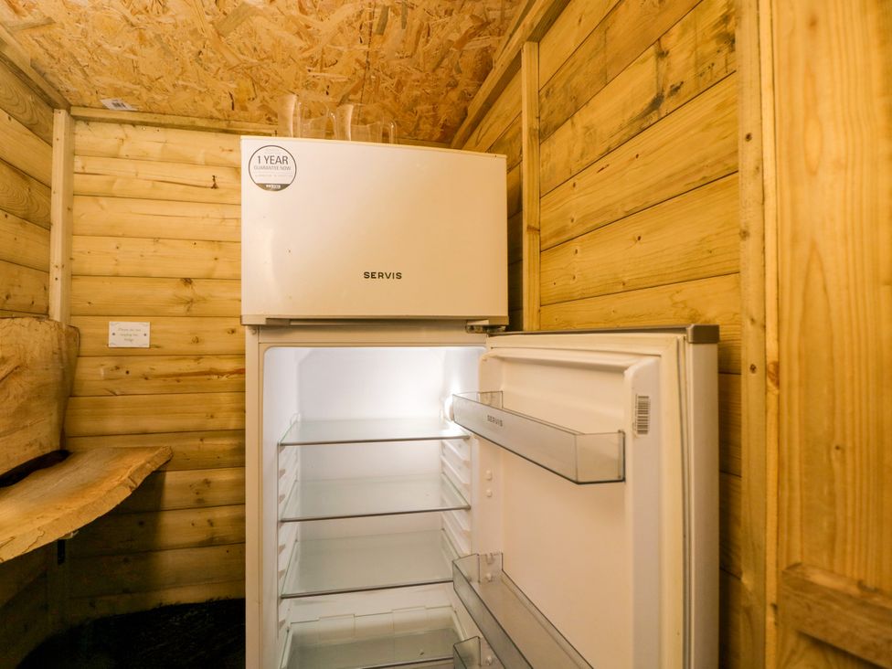 A refrigerator in a wooden cabin at The Moroccan Bell Tent in Woolton Hill