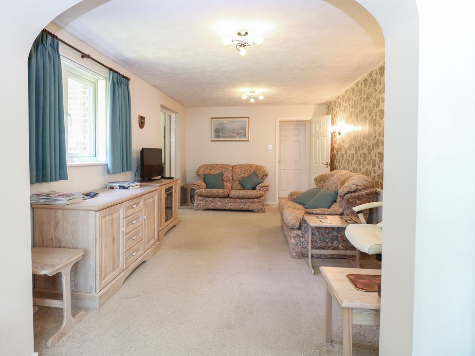 A living room with a sofa, television, and coffee table at 51 Colin McLean Road in Dereham